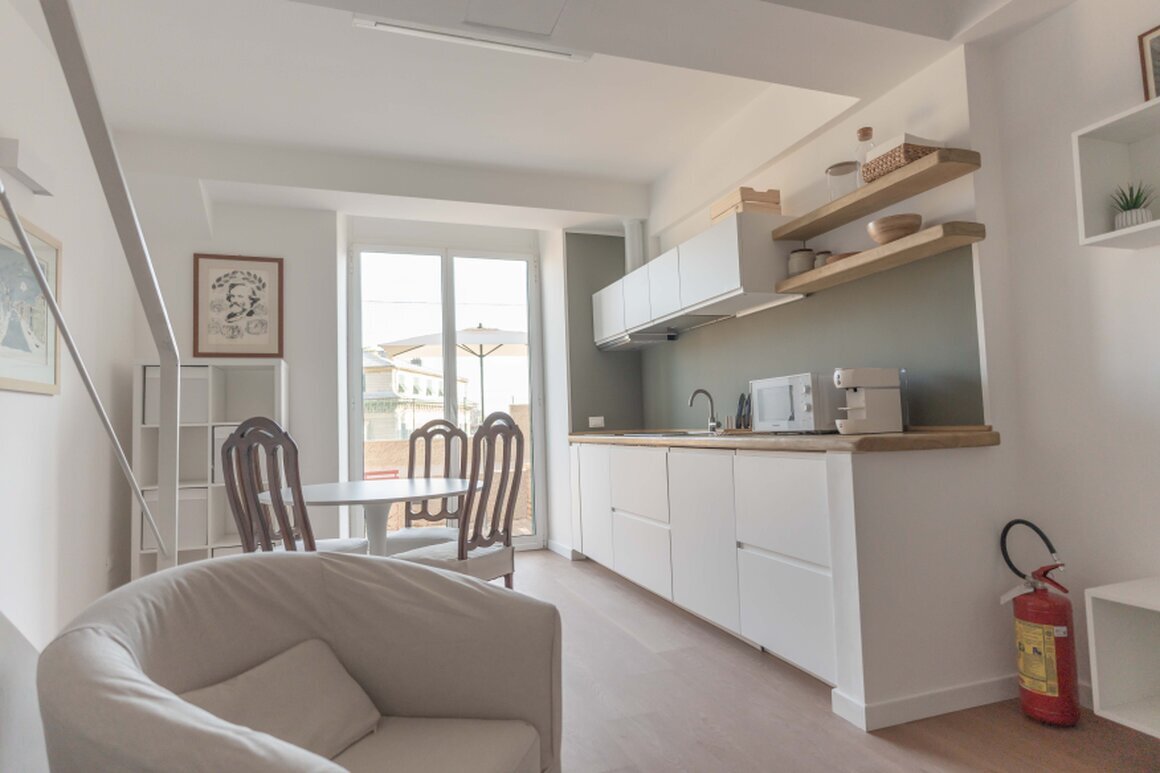 Soggiorno con cucina attrezzata in appartamento turistico a Genova.