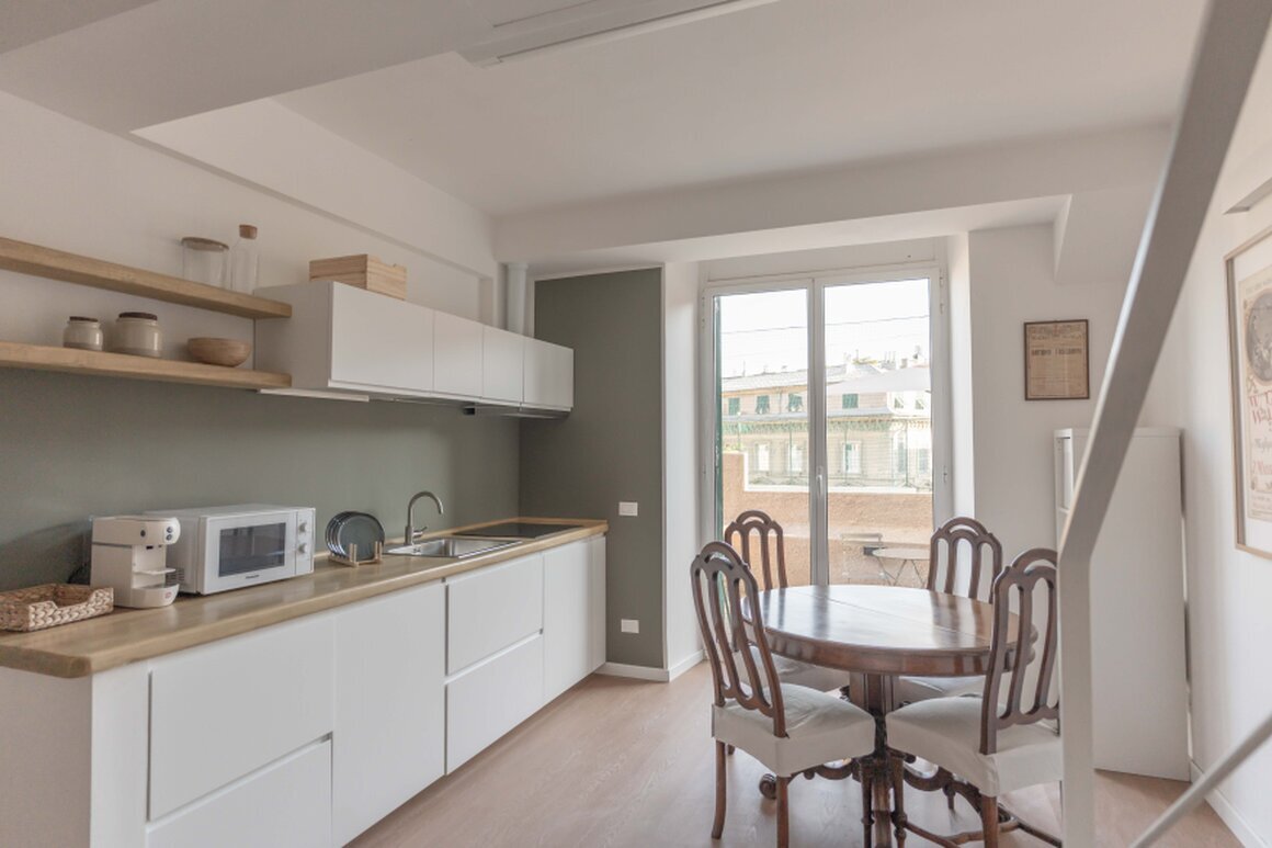 Soggiorno con cucina attrezzata in appartamento turistico a Genova.